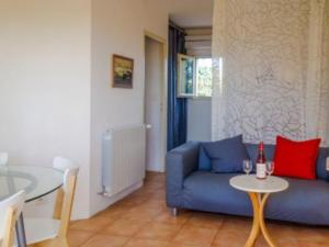 ein Wohnzimmer mit einem blauen Sofa und einem Tisch in der Unterkunft La Françonne Blanc - Gîte de charme en Provence in Mirabel-aux-Baronnies