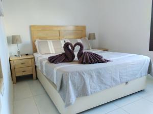 dois cisnes estão sentados em cima de uma cama em 3 Bedroom Luxury Apartment Villamartin em Orihuela