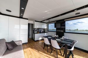 a kitchen and living room with a table and chairs at Houseboat Nomadream in Gdańsk