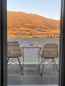 uma mesa e duas cadeiras sentadas numa varanda em Ninemia Naxos Suites em Naxos Chora