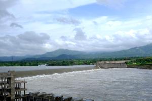 a river with a dam and mountains in the background at Hotel Sai Unity Room in Garudeshwar