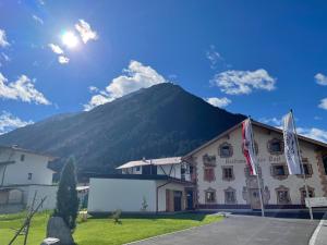 a hotel with a mountain in the background at Appartements Zur Post in Gries im Sellrain
