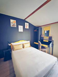 a bedroom with a large white bed and a desk at Hotel Abat Jour in Nantes