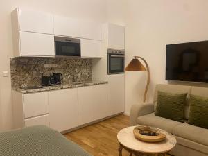 uma sala de estar com uma cozinha com um sofá e uma mesa em NaNa Flat em Praga