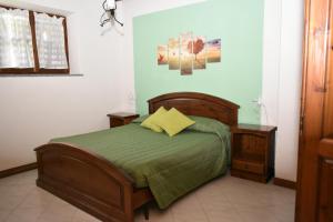 1 dormitorio con 1 cama con edredón verde en Le casette nel verde en Lurisia