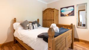 1 dormitorio con cama de madera y espejo en Sycamore Cottage with Hot Tub, en York