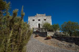 un edificio in pietra con piante di fronte di Castello Malicas a Galtellì