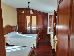 a bedroom with two beds and a door with a mirror at Casa Rural A Telleira in A Estrada
