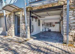 un garage vide avec un bâtiment en pierre dans l'établissement Stylish Thredbo Alpine Chalet + Garage in Tranquil Setting, à Thredbo