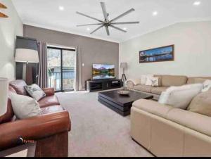 a living room with a couch and a table at Stylish Thredbo Alpine Chalet + Garage in Tranquil Setting in Thredbo