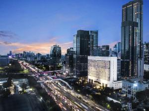 a city skyline at night with traffic on a highway at ARTOTEL Suites Mangkuluhur Jakarta in Jakarta