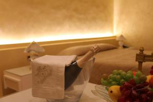 a room with a table with a bottle of champagne and fruit at Hotel Parco dei Principi in Foggia