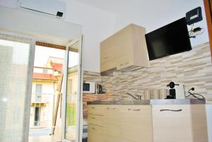 eine Küche mit einem Waschbecken und einem TV an der Wand in der Unterkunft Milan Shopping Street in Mailand