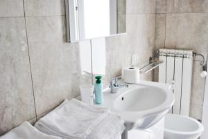ein weißes Badezimmer mit einem Waschbecken und einem Spiegel in der Unterkunft Milan Shopping Street in Mailand