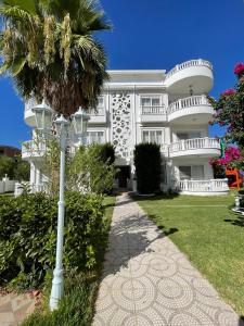 una casa bianca con una palma di fronte di Belka Golf Residence Exclusive Apt Poolside a Belek
