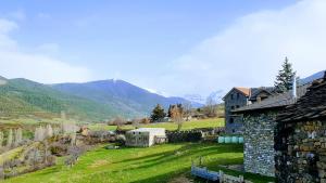 a stone building in a field with mountains in the background at Casa Fraile aisa in Aísa