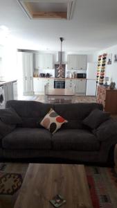 sala de estar con sofá y cocina en Torgoyle Cottage en Inverness