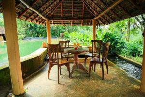 a table and chairs under a pavilion on a patio at Rainforest Edge in Kalawana