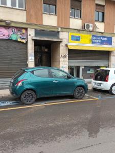 a green car parked in front of a building at Barirooms - Picca 24 in Bari