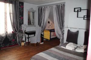 - une chambre avec un lit avec des rideaux et un bureau dans l'établissement Maison classée 50m océan de 2 à 12 personnes, à Mimizan