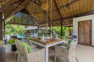 an outdoor dining area with a table and chairs at Bali Villa Home in Seminyak