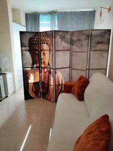 una habitación con una pintura de un buddha en la pared en Casa sol y mar 2I, en Torrevieja