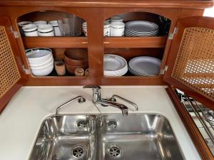 a sink in a kitchen with plates and dishes at Beautiful and comfortable sailboat with secure parking available in Barcelona
