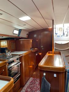 a kitchen with wooden cabinets and a stove top oven at Beautiful and comfortable sailboat with secure parking available in Barcelona