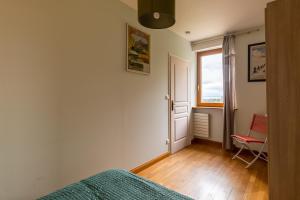托農萊班的住宿－Appartement 2p au Belvédère，一间卧室设有一张床、一个窗口和一把椅子