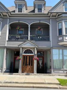 a gray house with a porch and a balcony at Redefined Alchemy - The Studio in Little Falls