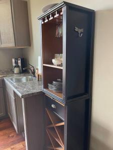 a cabinet in a kitchen with a sink at Redefined Alchemy - The Studio in Little Falls