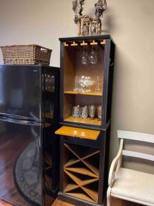 a black cabinet with glasses and a refrigerator at Redefined Alchemy - The Studio in Little Falls