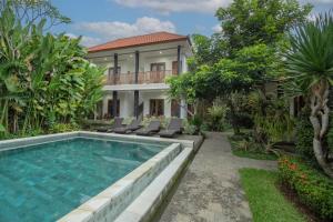 een villa met een zwembad en een huis bij Green Papaya House in Ubud
