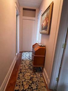 a hallway with a dresser and a door with a rug at Redefined Alchemy - The Studio in Little Falls
