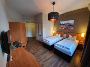 um quarto de hotel com duas camas e uma mesa em Hotel Friedensbruecke em Greiz