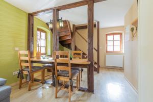 ein Esszimmer mit einem Tisch und einer Wendeltreppe in der Unterkunft Ferienhaus Schlag 