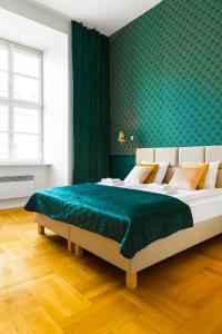 a bedroom with a large bed with a green wall at Glamorous Apartment in heart of Old Town in Krakow