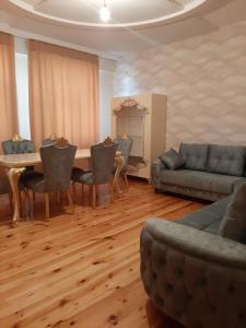 salon ze stołem, krzesłami i kanapą w obiekcie My sweet home in Qara Qarayev w mieście Baku