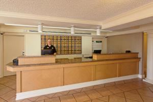 a man standing at a counter in a lobby at La Quinta Inn by Wyndham Costa Mesa Orange County in Costa Mesa