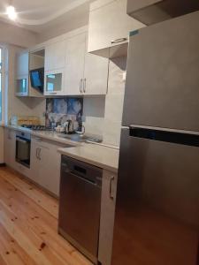 a kitchen with white cabinets and a stainless steel refrigerator at My sweet home in Qara Qarayev in Baku