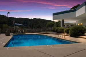 a large blue swimming pool in front of a building at Clarion Pointe Sylva near Cherokee Area in Dillsboro