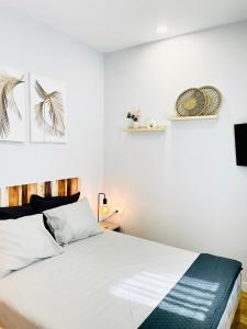 sypialnia z dużym białym łóżkiem z białą pościelą w obiekcie Villa Verde w Madrycie