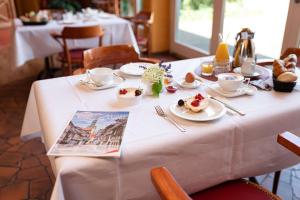 uma mesa com uma toalha de mesa branca com comida em elaya hotel wolfenbuettel ehemals Rilano 24 7 Hotel Wolfenbüttel em Volfembutel