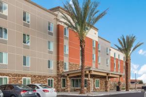 um edifício de apartamentos com palmeiras em frente em WoodSpring Suites Mesa Chandler em Mesa