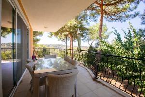 un patio con tavolo e sedie sul balcone. di Peaceful Home Surrounded by Nature in Kas a Gelemiş
