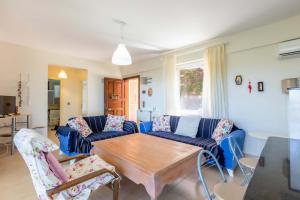 un soggiorno con divani blu e un tavolo in legno di Peaceful Home Surrounded by Nature in Kas a Gelemiş