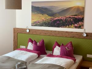 two beds in a room with a painting on the wall at Lil´s Dahoam in Zell am See