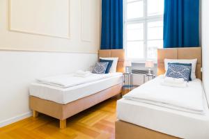 two beds in a room with blue curtains at Glamorous Apartment in heart of Old Town in Krakow