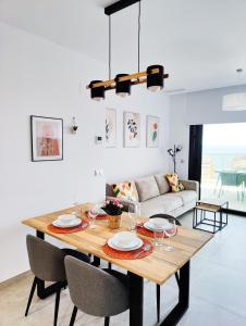 una sala da pranzo con tavolo, sedie e divano di SUNSET CLIFFS sea view apartments a Benidorm