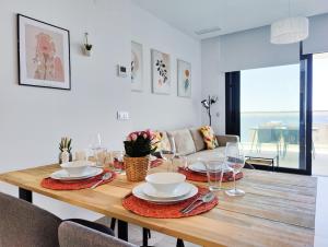 tavolo da pranzo con piatti e bicchieri di SUNSET CLIFFS sea view apartments a Benidorm